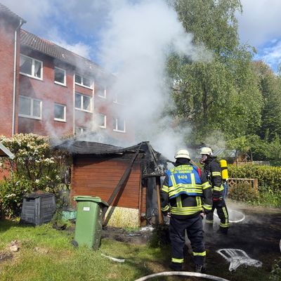 FW-AUR: Holzschuppen vor Wohngebäude in Vollbrand