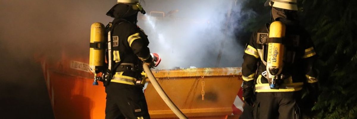 FW Hambühren: Nächtlicher Containerbrand neben Pflegeheim - Rauch droht durch geöffnete Fenster einzudringen