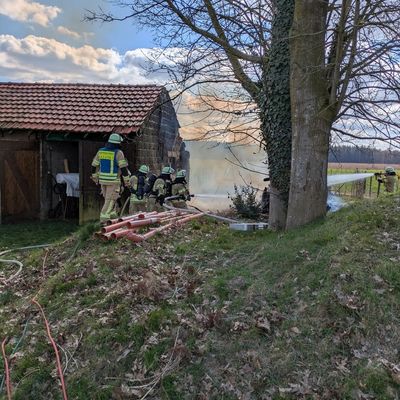 FW-KLE: Brand eines Holzstoßes - Übergreifen auf Scheune konnte verhindert werden