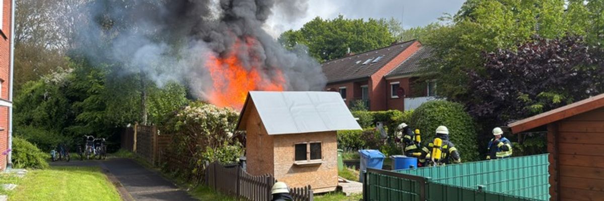FW-AUR: Holzschuppen vor Wohngebäude in Vollbrand