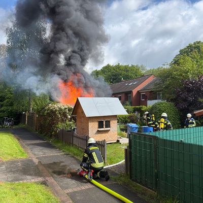 FW-AUR: Holzschuppen vor Wohngebäude in Vollbrand