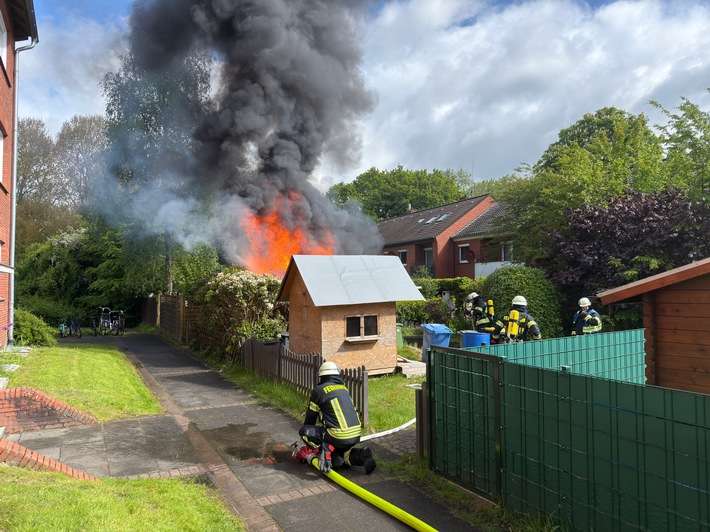 FW-AUR: Holzschuppen vor Wohngebäude in Vollbrand