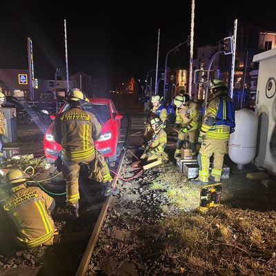 FW Weinheim: Auto landet auf den Gleisen am Bahnübergang Bergstraße. Feuerwehr hebt festgefahrenen Volkswagen mit Hebekissen aus dem Gleisbett
