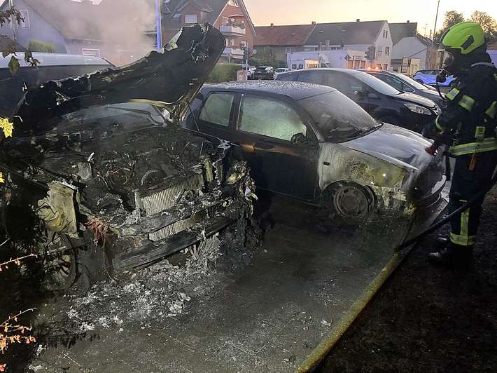 FW Bergheim: Feuerwehr löscht brennende Fahrzeuge in Bergheim Zwei PKW brannten auf Parkplatz - Auch angrenzende Hecke betroffen