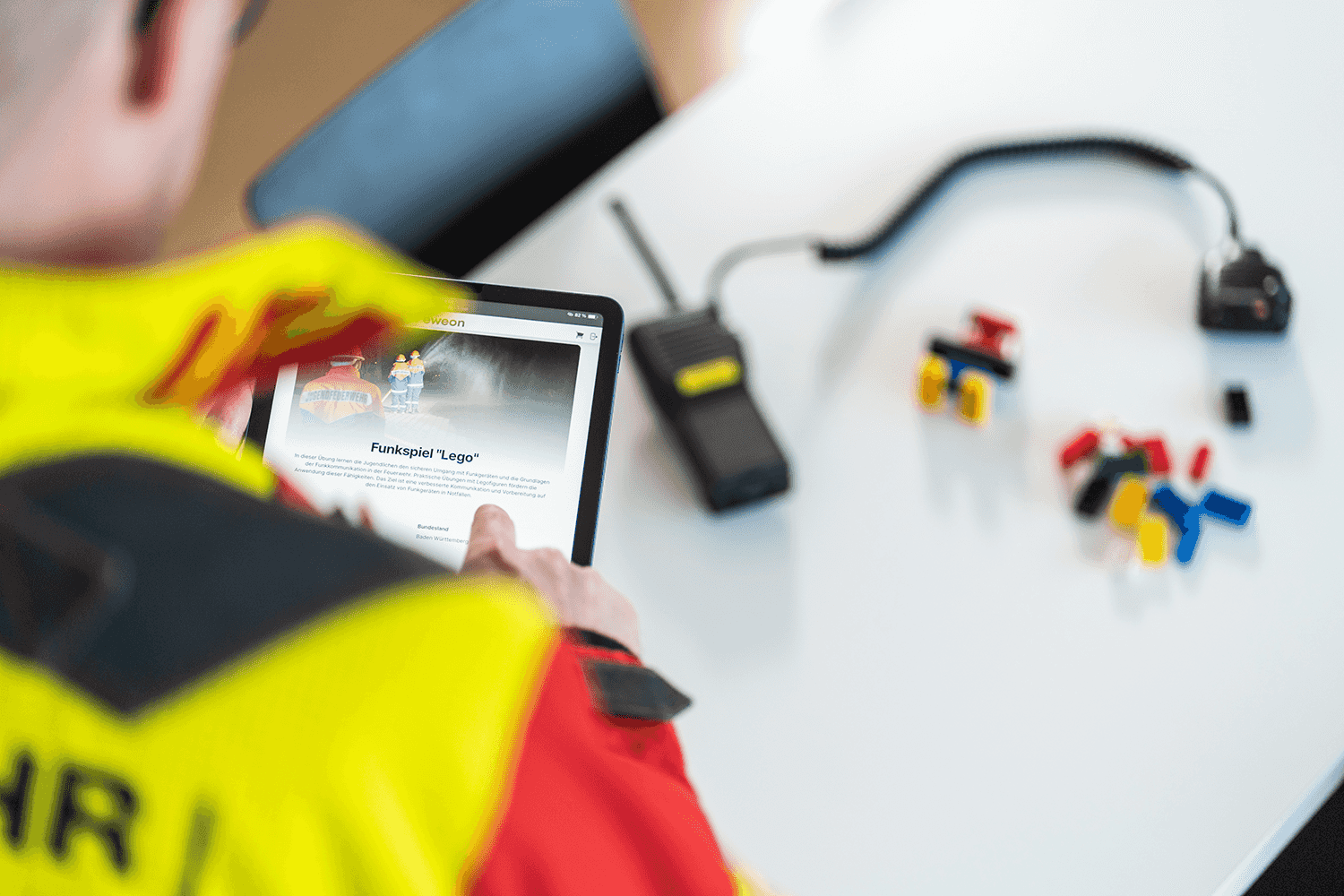 Feuerwehrmann begutachtet die Funkspiel-Lego Übung von Feweon.
