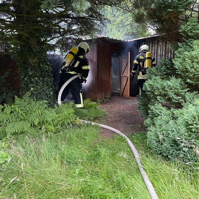 FW-AUR: Holzteile von Hütte und Zaun in Brand